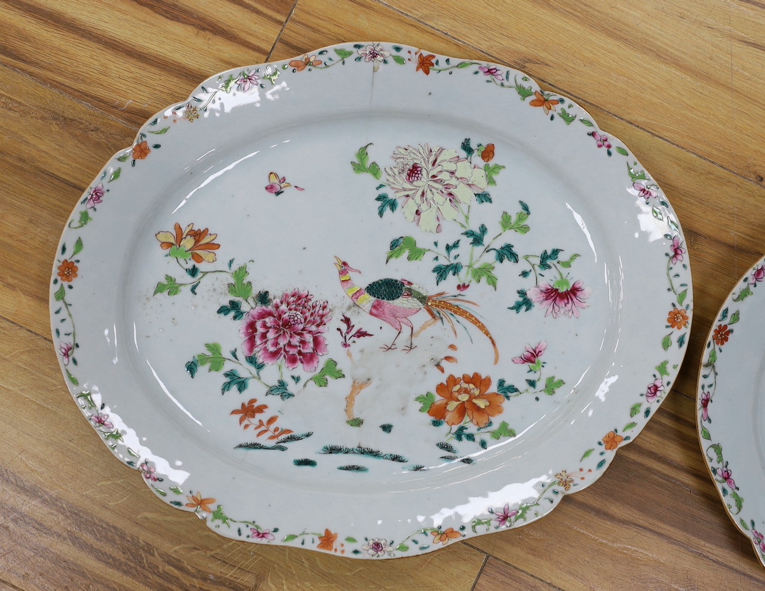 A pair of Chinese Famille Rose ‘peacock’ oval dishes, Qianlong period, 43cms wide